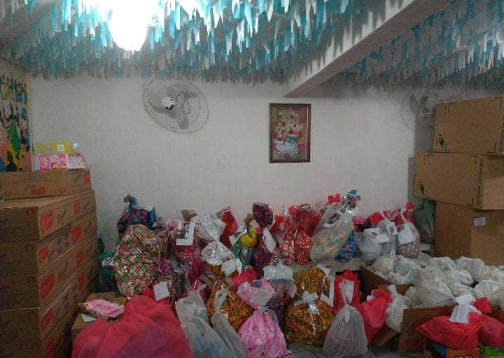 Sala decorada com presentes e cestas do Natal Solidário